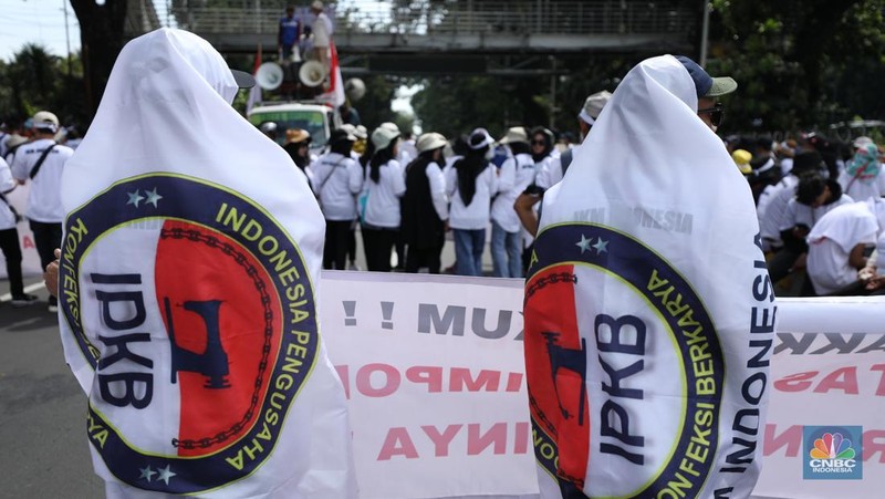 Ratusan buruh tekstil melakukan longmarch dari IRTI menuju Patung Kuda Jakarta, Kamis (27/6/2024). Massa yang tergabung dalam aliansi IKM & Pekerja Tekstil Indonesia menuntut tanggung jawab atas badai pemutusan hubungan kerja (PHK) di sejumlah industri tekstil dan produk tekstil (TPT) yang marak belakangan ini. (CNBC Indonesia/Tri Susilo)