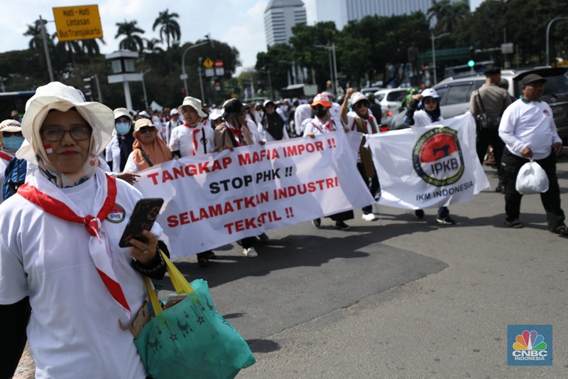 Ratusan buruh tekstil melakukan longmarch dari IRTI menuju Patung Kuda Jakarta, Kamis (27/6/2024). Massa yang tergabung dalam aliansi IKM & Pekerja Tekstil Indonesia menuntut tanggung jawab atas badai pemutusan hubungan kerja (PHK) di sejumlah industri tekstil dan produk tekstil (TPT) yang marak belakangan ini. Ratusan buruh tekstil melakukan longmarch dari IRTI menuju Patung Kuda Jakarta, Kamis (27/6/2024). Massa yang tergabung dalam aliansi IKM & Pekerja Tekstil Indonesia menuntut tanggung jawab atas badai pemutusan hubungan kerja (PHK) di sejumlah industri tekstil dan produk tekstil (TPT) yang marak belakangan ini. (CNBC Indonesia/Tri Susilo)
