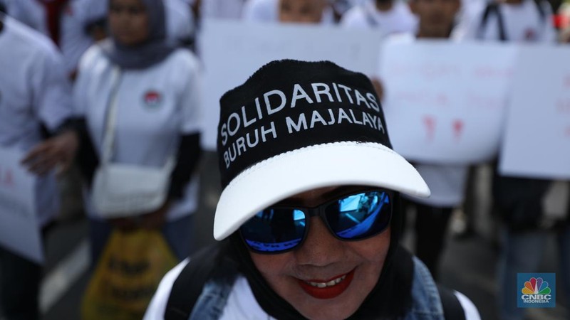 Ratusan buruh tekstil melakukan longmarch dari IRTI menuju Patung Kuda Jakarta, Kamis (27/6/2024). Massa yang tergabung dalam aliansi IKM & Pekerja Tekstil Indonesia menuntut tanggung jawab atas badai pemutusan hubungan kerja (PHK) di sejumlah industri tekstil dan produk tekstil (TPT) yang marak belakangan ini. (CNBC Indonesia/Tri Susilo)
