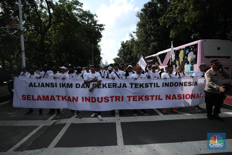 Ratusan buruh tekstil melakukan longmarch dari IRTI menuju Patung Kuda Jakarta, Kamis (27/6/2024). Massa yang tergabung dalam aliansi IKM & Pekerja Tekstil Indonesia menuntut tanggung jawab atas badai pemutusan hubungan kerja (PHK) di sejumlah industri tekstil dan produk tekstil (TPT) yang marak belakangan ini. Ratusan buruh tekstil melakukan longmarch dari IRTI menuju Patung Kuda Jakarta, Kamis (27/6/2024). Massa yang tergabung dalam aliansi IKM & Pekerja Tekstil Indonesia menuntut tanggung jawab atas badai pemutusan hubungan kerja (PHK) di sejumlah industri tekstil dan produk tekstil (TPT) yang marak belakangan ini. (CNBC Indonesia/Tri Susilo)