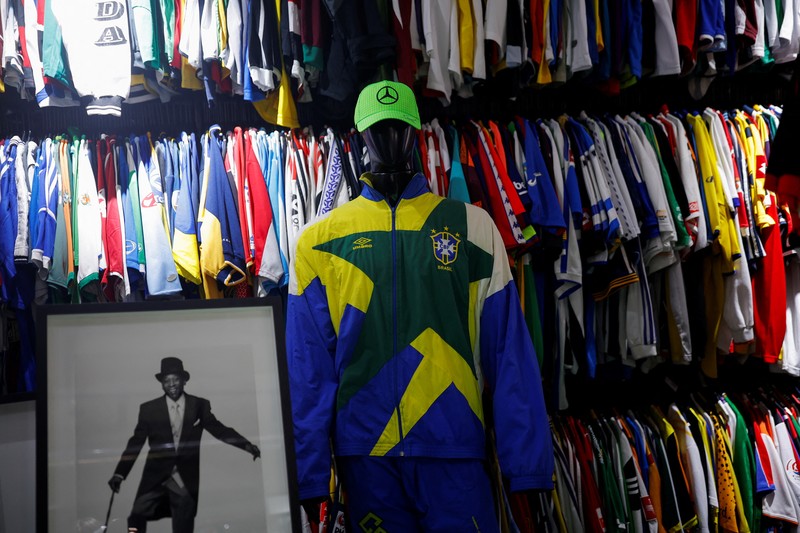 Cassio Brandao, 41, holds a shirt worn by Pele during a match with the presence of Britain's Queen Elizabeth in 1968, in a room filled with clothes racks that in April 2024 made him become a Guinness World Records title holder, as the owner of the world's largest collection of soccer shirts, in Sao Paulo, Brazil June 24, 2024. REUTERS/Amanda Perobelli