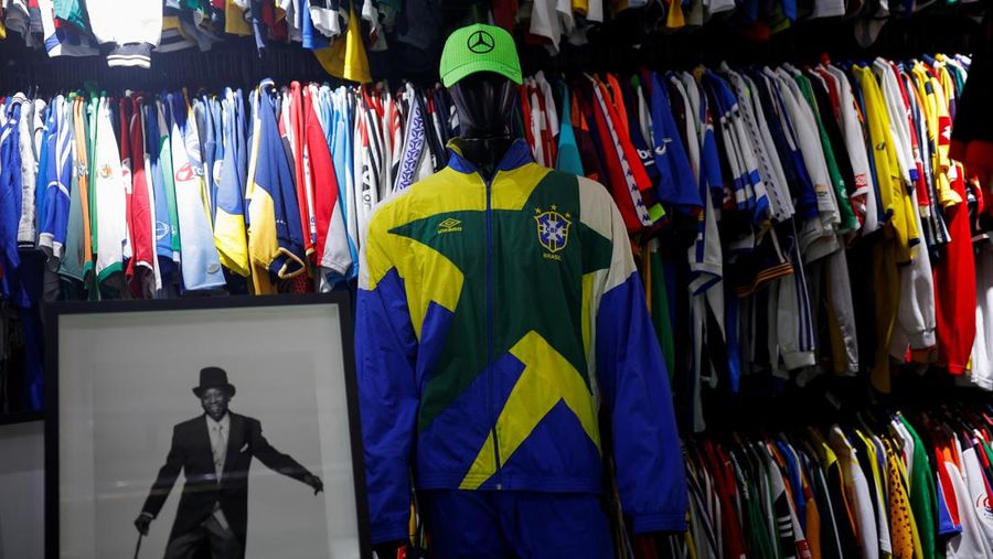 Cassio Brandao, 41, holds a shirt worn by Pele during a match with the presence of Britain's Queen Elizabeth in 1968, in a room filled with clothes racks that in April 2024 made him become a Guinness World Records title holder, as the owner of the world's largest collection of soccer shirts, in Sao Paulo, Brazil June 24, 2024. REUTERS/Amanda Perobelli