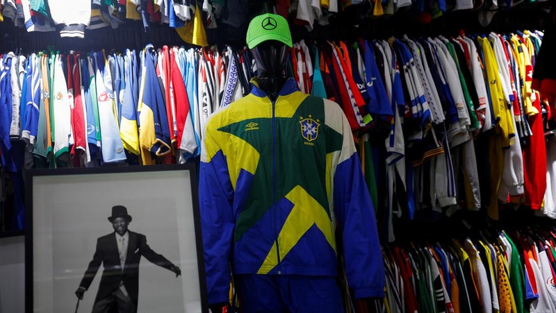 Cassio Brandao, 41, holds a shirt worn by Pele during a match with the presence of Britain's Queen Elizabeth in 1968, in a room filled with clothes racks that in April 2024 made him become a Guinness World Records title holder, as the owner of the world's largest collection of soccer shirts, in Sao Paulo, Brazil June 24, 2024. REUTERS/Amanda Perobelli