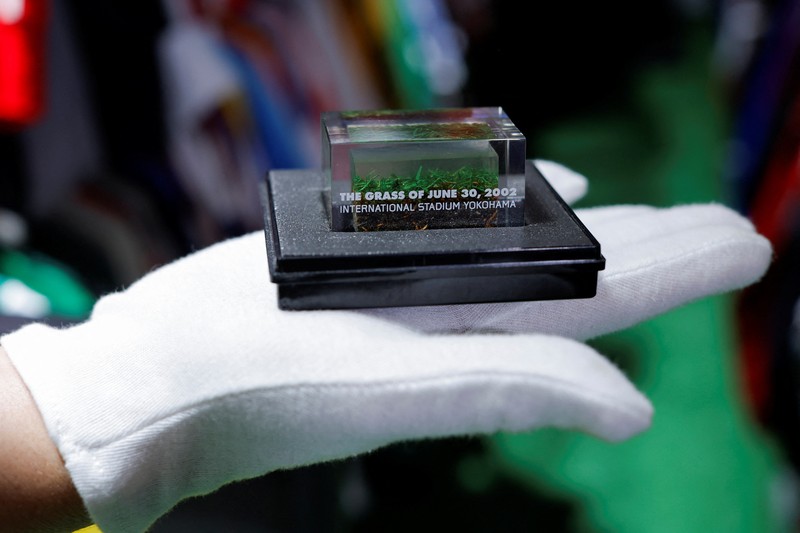 Cassio Brandao, 41, holds a shirt worn by Pele during a match with the presence of Britain's Queen Elizabeth in 1968, in a room filled with clothes racks that in April 2024 made him become a Guinness World Records title holder, as the owner of the world's largest collection of soccer shirts, in Sao Paulo, Brazil June 24, 2024. REUTERS/Amanda Perobelli