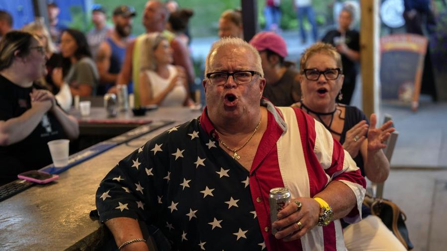 Orang-orang menghadiri pesta debat presiden AS pertama yang diselenggarakan oleh CNN di Atlanta, di Union Pub di Capitol Hill di Washington, AS, 27 Juni 2024. (REUTERS/Nathan Howard)