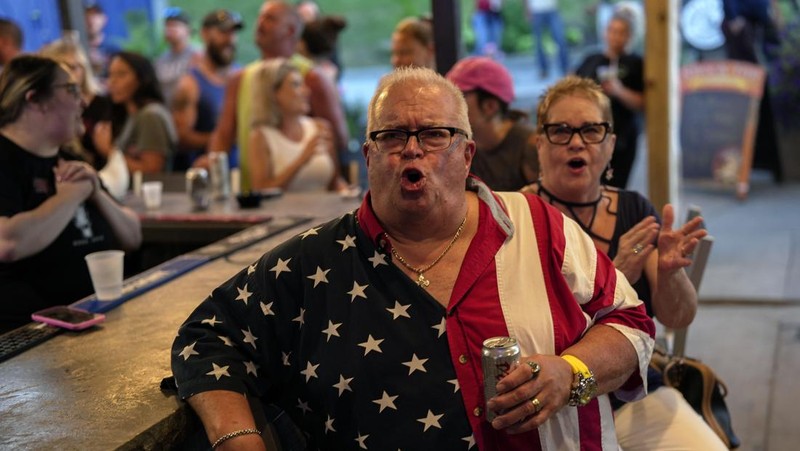 Orang-orang menghadiri pesta debat presiden AS pertama yang diselenggarakan oleh CNN di Atlanta, di Union Pub di Capitol Hill di Washington, AS, 27 Juni 2024. (REUTERS/Nathan Howard)