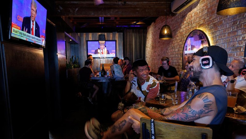 Orang-orang menghadiri pesta debat presiden AS pertama yang diselenggarakan oleh CNN di Atlanta, di Union Pub di Capitol Hill di Washington, AS, 27 Juni 2024. (REUTERS/Nathan Howard)