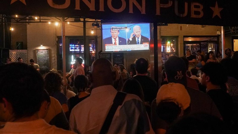 Orang-orang menghadiri pesta debat presiden AS pertama yang diselenggarakan oleh CNN di Atlanta, di Union Pub di Capitol Hill di Washington, AS, 27 Juni 2024. (REUTERS/Nathan Howard)