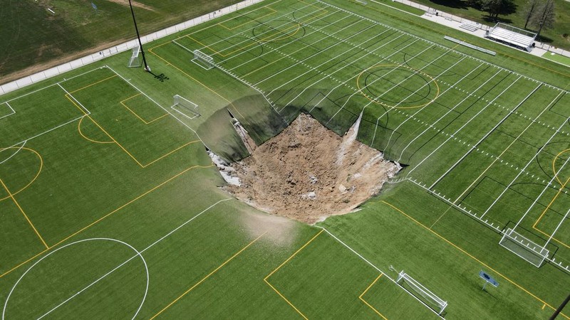 Rekaman drone menunjukkan lubang pembuangan terbentuk di lapangan sepak bola di Gordon Moore Park di Alton, Illinois, Amerika Serikat pada 27 Juni 2024.  (REUTERS/Lawrence Bryant)