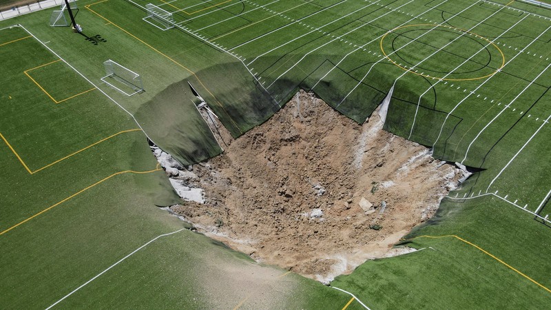 Pemandangan drone menunjukkan lubang pembuangan yang terbentuk di lapangan sepak bola di Gordon Moore Park di Alton, Illinois, AS, 27 Juni 2024. (REUTERS/Lawrence Bryant)