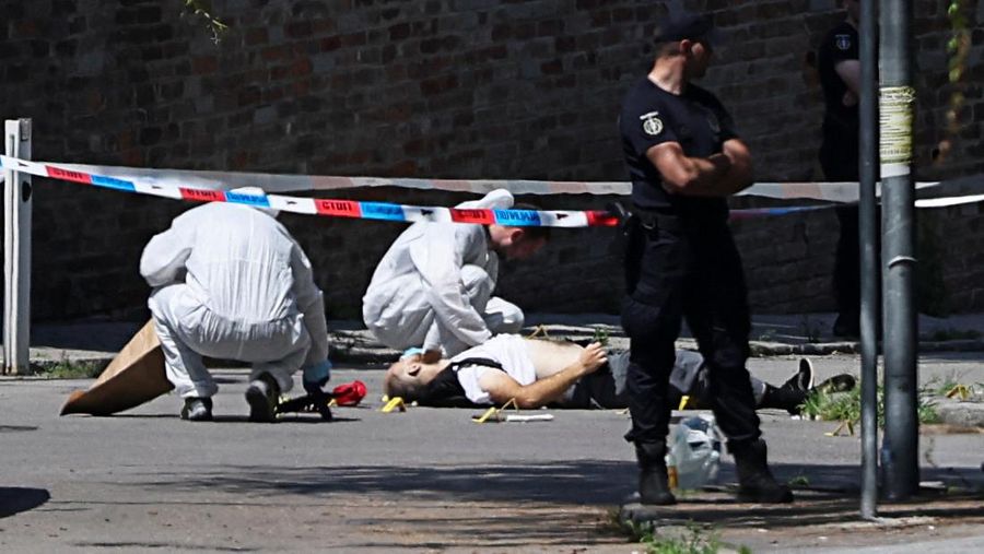 Petugas kepolisian mengangkat jenazah seorang pria yang tewas usai melakukan penyerangan terhadap polisi di depan kantor Kedutaan Besar (Kedubes) Israel, Beograd, Serbia, Sabtu (29/6/2024). (REUTERS/Zorana Jevtic)