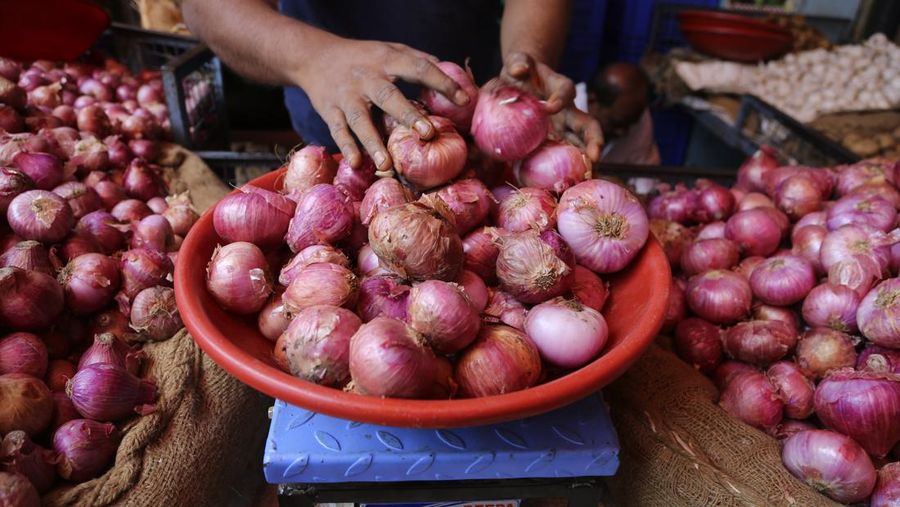 Seorang penjual menimbang bawang untuk pelanggan di pasar petani di Bangalore, India. (AP Photo/Aijaz Rahi/File Foto)