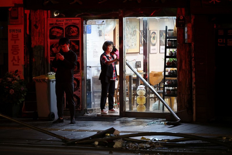 Polisi dan tim penyelamat berdiri di samping mobil yang terlibat dalam kecelakaan yang mengakibatkan beberapa orang tewas dan terluka di pusat kota Seoul, Korea Selatan 1 Juli 2024. (REUTERS/Kim Hong-Ji)