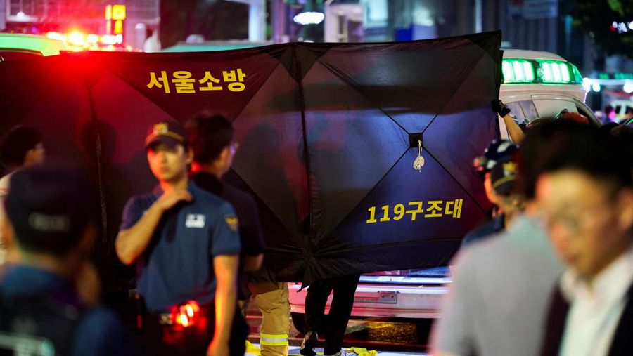 Polisi dan tim penyelamat berdiri di samping mobil yang terlibat dalam kecelakaan yang mengakibatkan beberapa orang tewas dan terluka di pusat kota Seoul, Korea Selatan 1 Juli 2024. (REUTERS/Kim Hong-Ji)