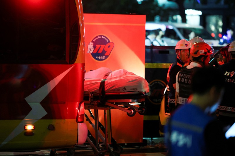 Polisi dan tim penyelamat berdiri di samping mobil yang terlibat dalam kecelakaan yang mengakibatkan beberapa orang tewas dan terluka di pusat kota Seoul, Korea Selatan 1 Juli 2024. (REUTERS/Kim Hong-Ji)