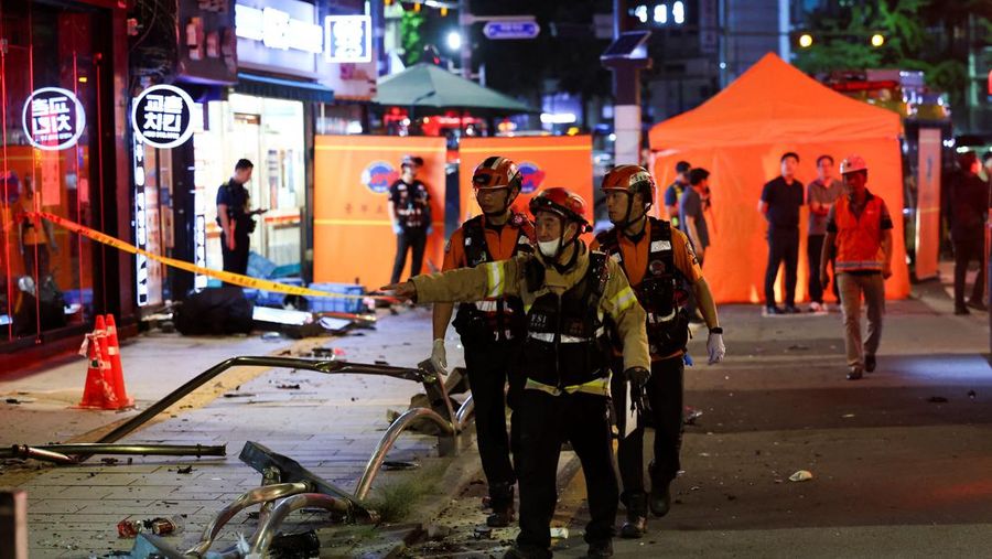 Polisi dan tim penyelamat berdiri di samping mobil yang terlibat dalam kecelakaan yang mengakibatkan beberapa orang tewas dan terluka di pusat kota Seoul, Korea Selatan 1 Juli 2024. (REUTERS/Kim Hong-Ji)