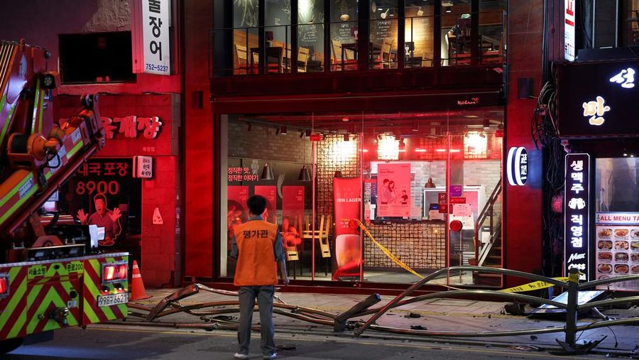 Polisi dan tim penyelamat berdiri di samping mobil yang terlibat dalam kecelakaan yang mengakibatkan beberapa orang tewas dan terluka di pusat kota Seoul, Korea Selatan 1 Juli 2024. (REUTERS/Kim Hong-Ji)