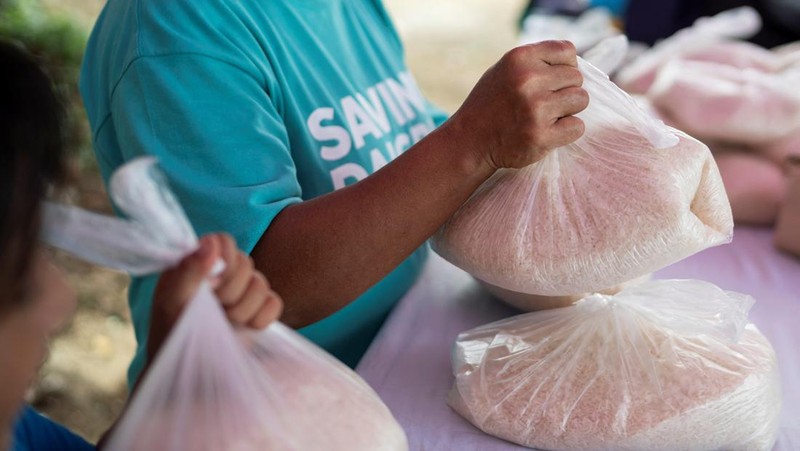 Orang-orang mengumpulkan sampah plastik di pantai saat program pembersihan pantai yang menyediakan beras kepada relawan sebagai imbalan atas sampah plastik, di Mabini, provinsi Batangas, Filipina, 15 Juni 2024. (REUTERS/Lisa Marie David)