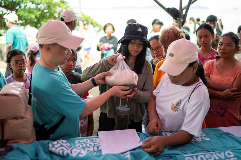 Orang-orang mengumpulkan sampah plastik di pantai saat program pembersihan pantai yang menyediakan beras kepada relawan sebagai imbalan atas sampah plastik, di Mabini, provinsi Batangas, Filipina, 15 Juni 2024. Orang-orang mengumpulkan sampah plastik di pantai saat program pembersihan pantai yang menyediakan beras kepada relawan sebagai imbalan atas sampah plastik, di Mabini, provinsi Batangas, Filipina, 15 Juni 2024. (REUTERS/Lisa Marie David)