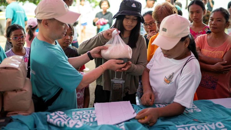 Orang-orang mengumpulkan sampah plastik di pantai saat program pembersihan pantai yang menyediakan beras kepada relawan sebagai imbalan atas sampah plastik, di Mabini, provinsi Batangas, Filipina, 15 Juni 2024. (REUTERS/Lisa Marie David)