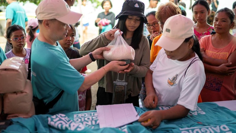 Orang-orang mengumpulkan sampah plastik di pantai saat program pembersihan pantai yang menyediakan beras kepada relawan sebagai imbalan atas sampah plastik, di Mabini, provinsi Batangas, Filipina, 15 Juni 2024. (REUTERS/Lisa Marie David)