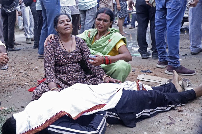 Wanita berduka di samping jenazah kerabatnya di luar rumah sakit Sikandrarao di distrik Hathras sekitar 350 kilometer (217 mil) barat daya Lucknow, India, Selasa, 2 Juli 2024. Sedikitnya 60 orang tewas dan banyak lainnya terluka setelah terinjak-injak di pertemuan keagamaan ribuan orang di India utara, kata para pejabat Selasa. (AP Photo/Manoj Aligadi)