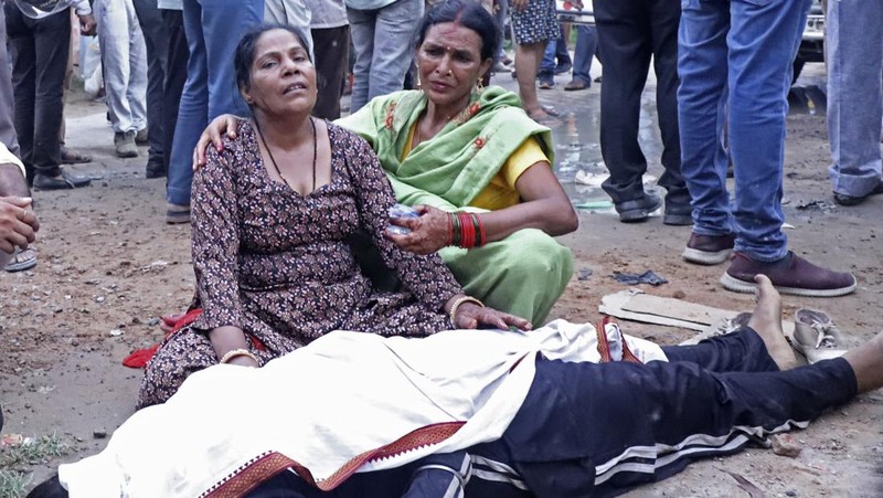 Wanita berduka di samping jenazah kerabatnya di luar rumah sakit Sikandrarao di distrik Hathras sekitar 350 kilometer (217 mil) barat daya Lucknow, India, Selasa, 2 Juli 2024. Sedikitnya 60 orang tewas dan banyak lainnya terluka setelah terinjak-injak di pertemuan keagamaan ribuan orang di India utara, kata para pejabat Selasa. (AP Photo/Manoj Aligadi)