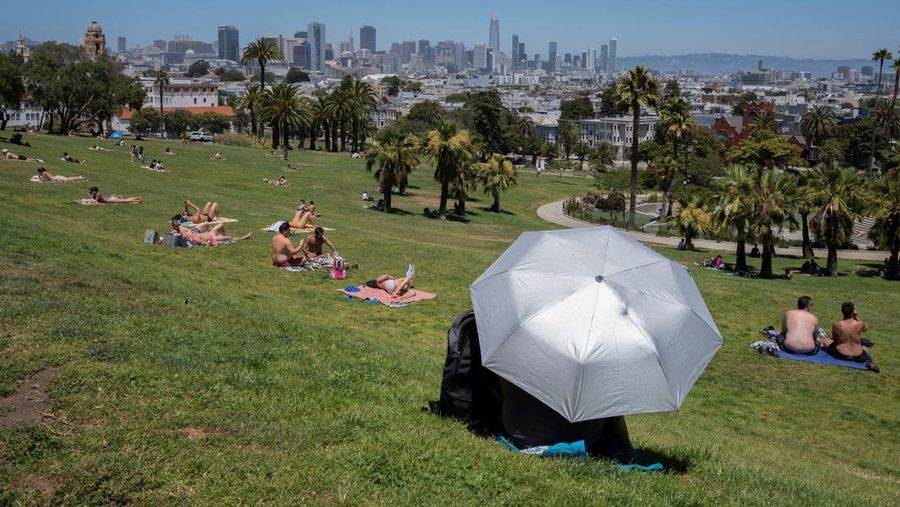 Orang-orang beristirahat di Dolores Park saat terjadi gelombang panas saat suhu naik hingga lebih dari 80 Fahrenheit (26,7 derajat Celcius), di San Francisco, California, AS, 2 Juli 2024. (REUTERS/Emily Steinberger)