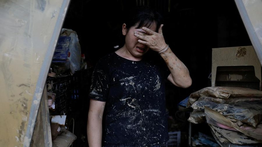 Sebuah mobil dan tumpukan puing-puing terlihat di jalan setelah banjir menyusul hujan lebat di daerah Pingjiang, Yueyang, provinsi Hunan, Tiongkok 3 Juli 2024. (REUTERS/Tingshu Wang)