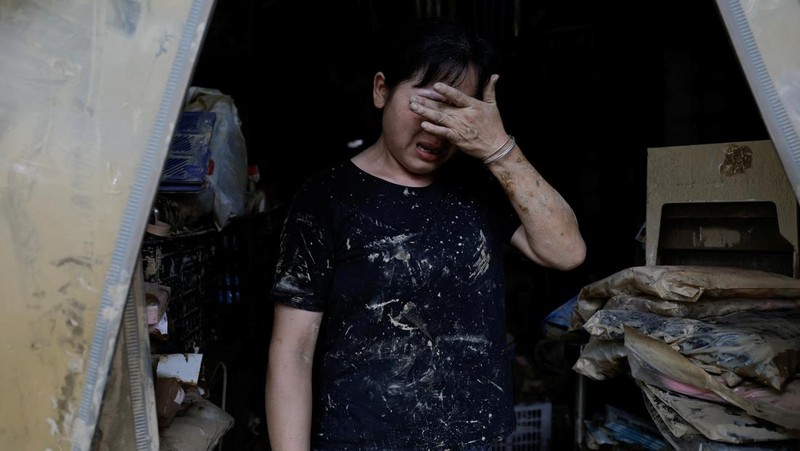 Sebuah mobil dan tumpukan puing-puing terlihat di jalan setelah banjir menyusul hujan lebat di daerah Pingjiang, Yueyang, provinsi Hunan, Tiongkok 3 Juli 2024. (REUTERS/Tingshu Wang)