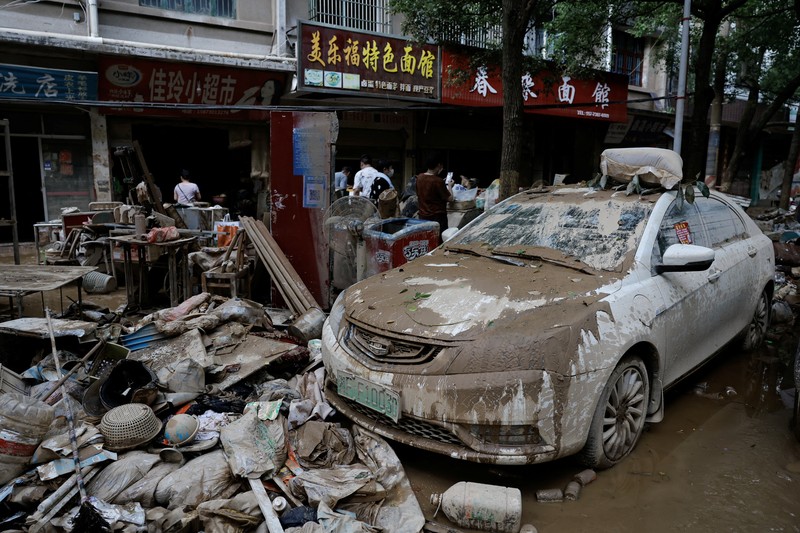 Sebuah mobil dan tumpukan puing-puing terlihat di jalan setelah banjir menyusul hujan lebat di daerah Pingjiang, Yueyang, provinsi Hunan, Tiongkok 3 Juli 2024. Sebuah mobil dan tumpukan puing-puing terlihat di jalan setelah banjir menyusul hujan lebat di daerah Pingjiang, Yueyang, provinsi Hunan, Tiongkok 3 Juli 2024. (REUTERS/Tingshu Wang)