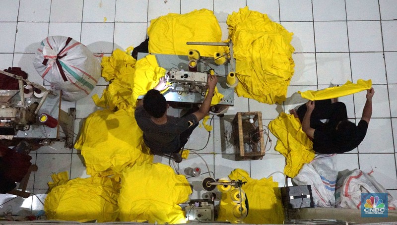 Sejumlah pekerja menyelesaikan kaos pesanan di konveksi Sinergi Adv kawasan Serengseng Sawah, Jakarta, Kamis, (4/7/2024). (CNBC Indonesia/Muhammad Sabki)