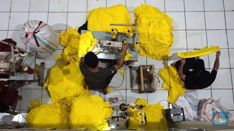 Sejumlah pekerja menyelesaikan kaos pesanan di konveksi Sinergi Adv kawasan Serengseng Sawah, Jakarta, Kamis, (4/7/2024). (CNBC Indonesia/Muhammad Sabki)