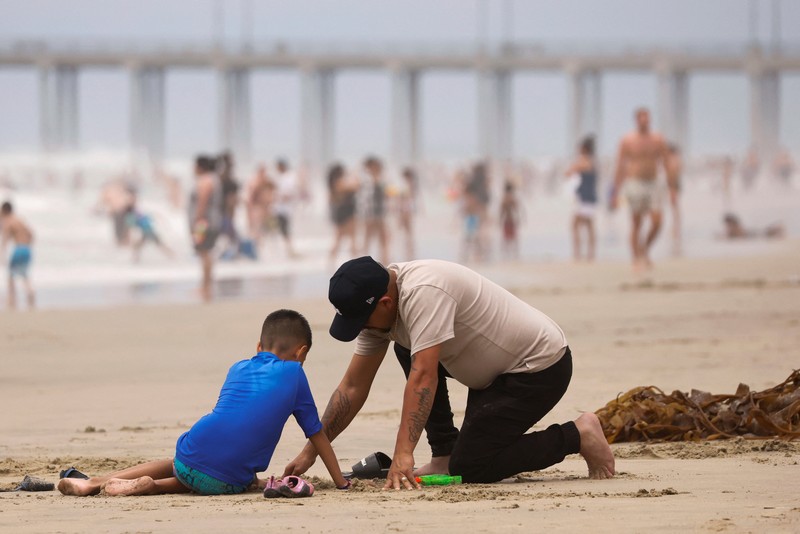 Orang-orang menikmati pantai pada liburan Hari Kemerdekaan Empat Juli saat cuaca panas di Huntington Beach, California, AS 4 Juli 2024. Orang-orang menikmati pantai pada liburan Hari Kemerdekaan Empat Juli saat cuaca panas di Huntington Beach, California, AS 4 Juli 2024. (REUTERS/Etienne Laurent)