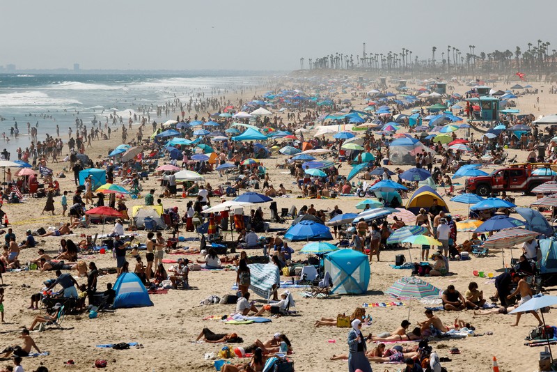 Orang-orang menikmati pantai pada liburan Hari Kemerdekaan Empat Juli saat cuaca panas di Huntington Beach, California, AS 4 Juli 2024. (REUTERS/Etienne Laurent)