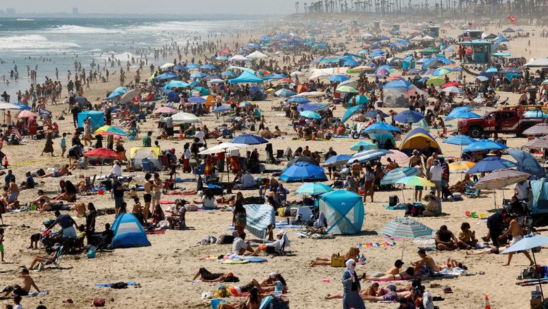 Orang-orang menikmati pantai pada liburan Hari Kemerdekaan Empat Juli saat cuaca panas di Huntington Beach, California, AS 4 Juli 2024. (REUTERS/Etienne Laurent)