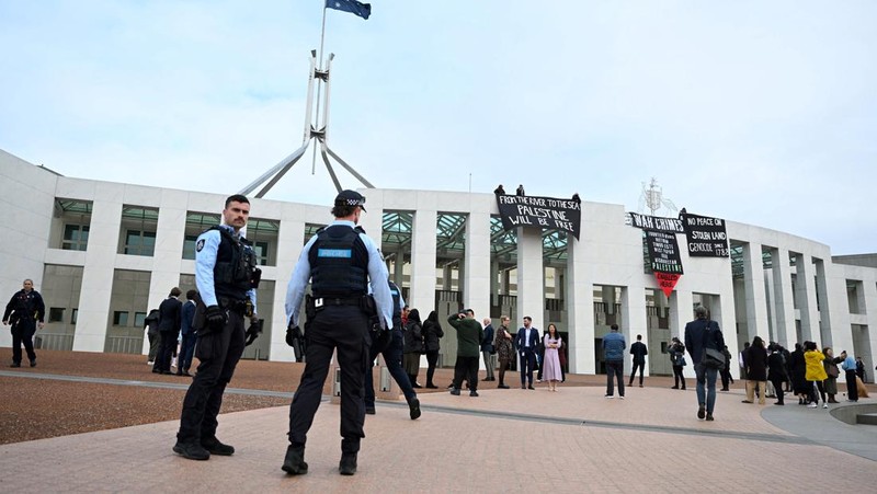 Pengunjuk rasa pro-Palestina menggantung spanduk di puncak Gedung Parlemen di Canberra, Australia, 4 Juli 2024. (AAP/Lukas Coch via REUTERS)