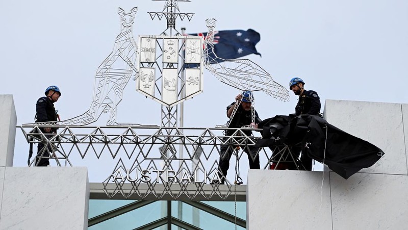 Pengunjuk rasa pro-Palestina menggantung spanduk di puncak Gedung Parlemen di Canberra, Australia, 4 Juli 2024. (AAP/Lukas Coch via REUTERS)