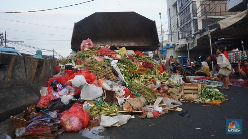 Seorang anak melintas di samping alat berat saat penanganan tumpukan sampah organik dan sisa makanan di kawasan Pasar Minggu, Jakarta, Jumat, (5/7/2024). Seorang anak melintas di samping alat berat saat penanganan tumpukan sampah organik dan sisa makanan di kawasan Pasar Minggu, Jakarta, Jumat, (5/7/2024). (CNBC Indonesia/Muhammad Sabki)