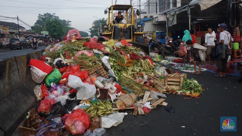 Seorang anak melintas di samping alat berat saat penanganan tumpukan sampah organik dan sisa makanan di kawasan Pasar Minggu, Jakarta, Jumat, (5/7/2024). Seorang anak melintas di samping alat berat saat penanganan tumpukan sampah organik dan sisa makanan di kawasan Pasar Minggu, Jakarta, Jumat, (5/7/2024). (CNBC Indonesia/Muhammad Sabki)