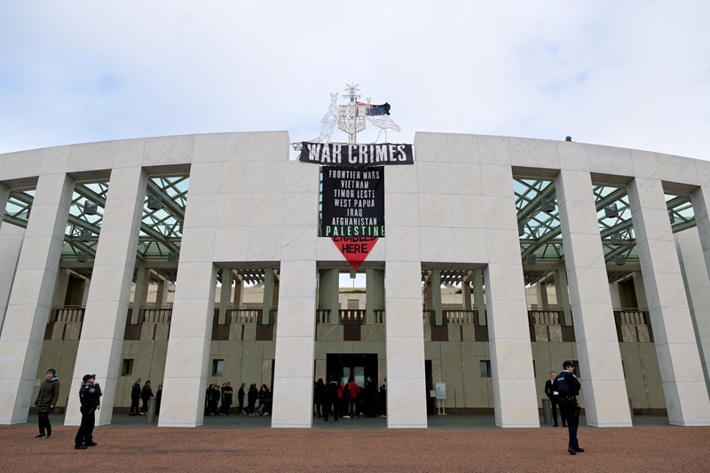 Pengunjuk rasa pro-Palestina menggantung spanduk di puncak Gedung Parlemen di Canberra, Australia, 4 Juli 2024. (AAP/Lukas Coch via REUTERS)