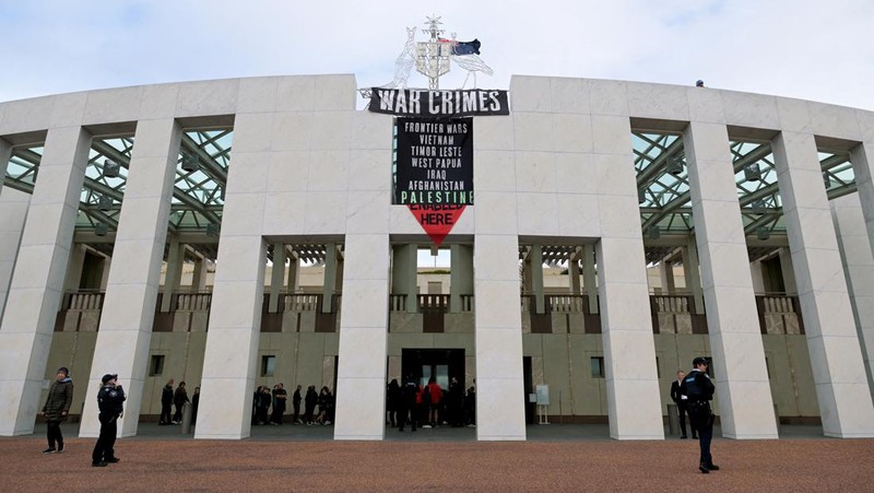 Pengunjuk rasa pro-Palestina menggantung spanduk di puncak Gedung Parlemen di Canberra, Australia, 4 Juli 2024. (AAP/Lukas Coch via REUTERS)