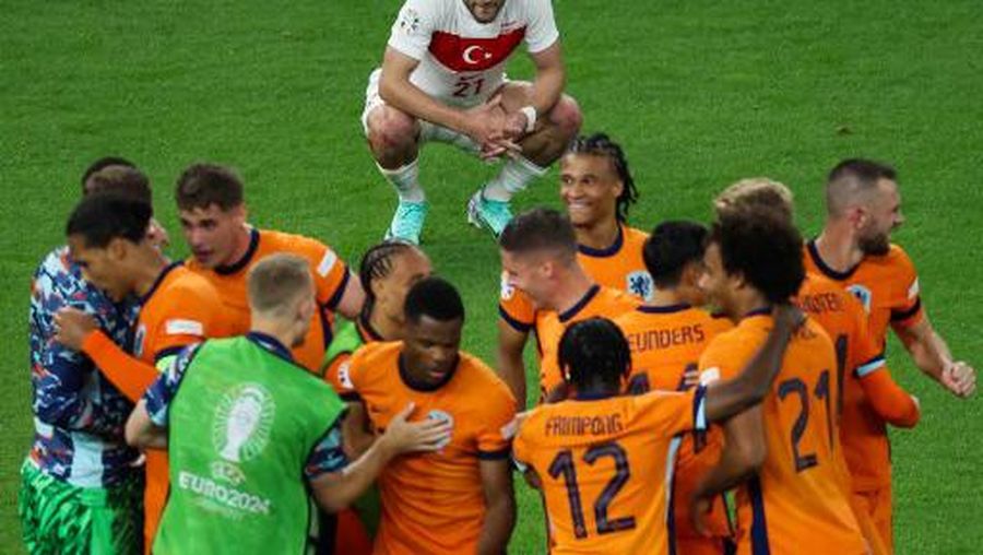 Turkey's forward #21 Baris Alper Yilmaz reacts as Netherlands' players celebrate after the UEFA Euro 2024 quarter-final football match between the Netherlands and Turkey at the Olympiastadion Berlin in Berlin on July 6, 2024. (Photo by Ronny HARTMANN / AFP)