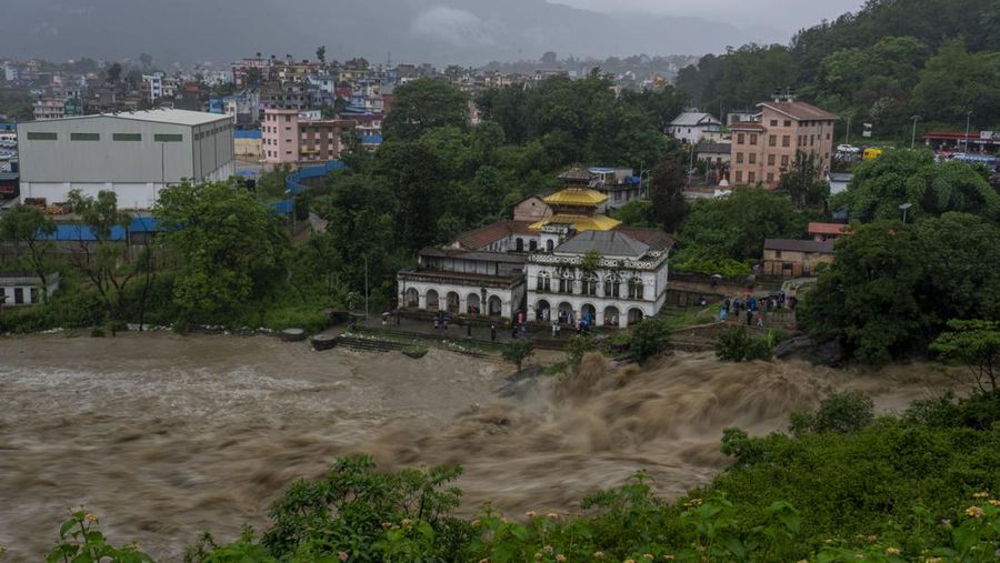 Masyarakat menyaksikan banjirnya sungai Bagmati di Kathmandu, Nepal, Sabtu, 6 Juli 2024. (AP Photo/Niranjan Shrestha)