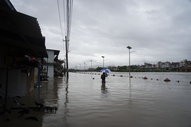 Masyarakat menyaksikan banjirnya sungai Bagmati di Kathmandu, Nepal, Sabtu, 6 Juli 2024. (AP Photo/Niranjan Shrestha)