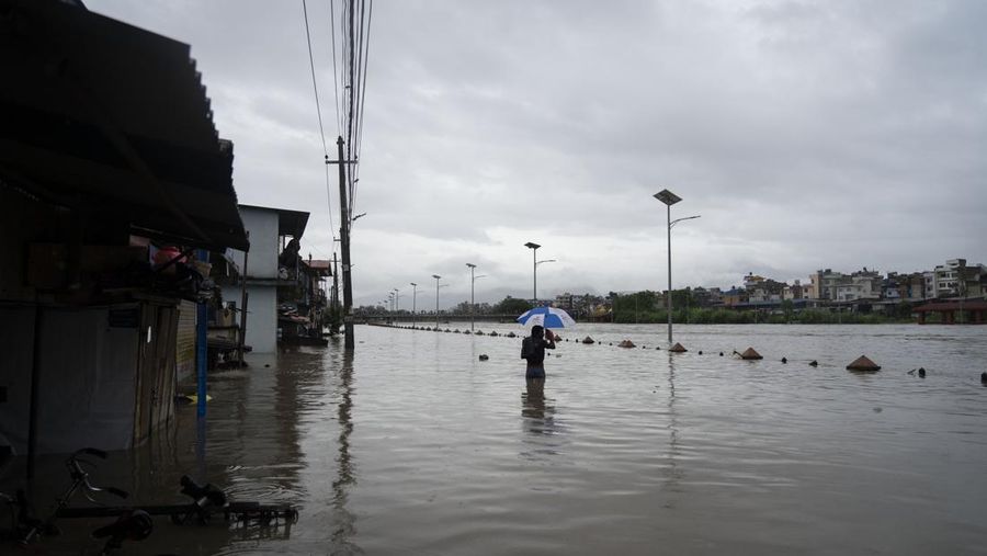 Masyarakat menyaksikan banjirnya sungai Bagmati di Kathmandu, Nepal, Sabtu, 6 Juli 2024. (AP Photo/Niranjan Shrestha)