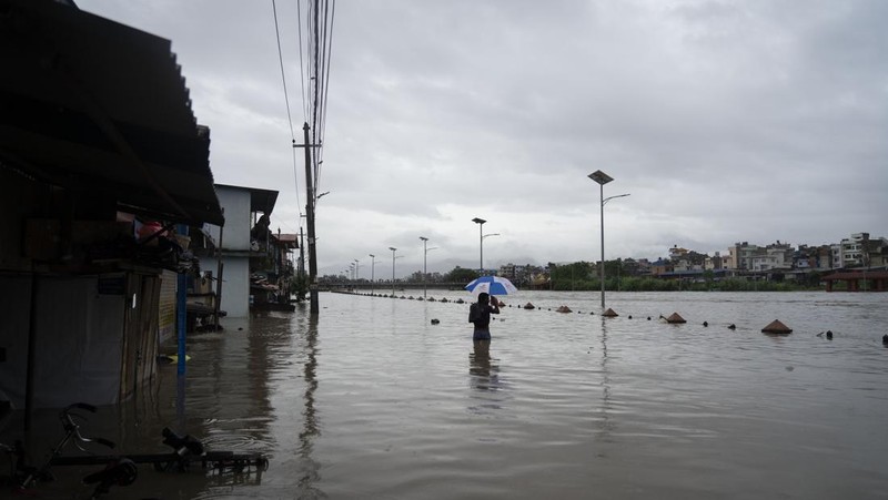 Masyarakat menyaksikan banjirnya sungai Bagmati di Kathmandu, Nepal, Sabtu, 6 Juli 2024. (AP Photo/Niranjan Shrestha)