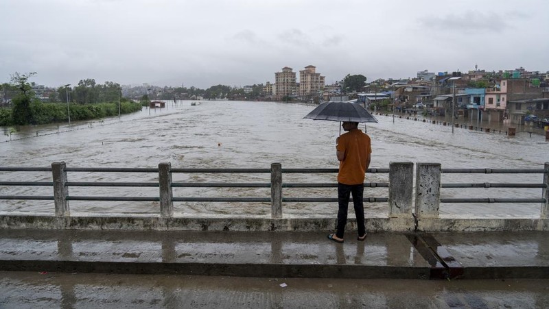 Masyarakat menyaksikan banjirnya sungai Bagmati di Kathmandu, Nepal, Sabtu, 6 Juli 2024. (AP Photo/Niranjan Shrestha)