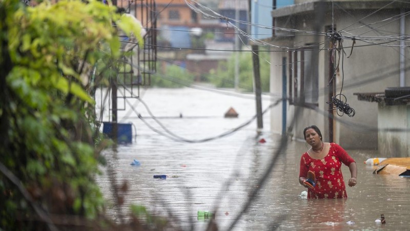 Masyarakat menyaksikan banjirnya sungai Bagmati di Kathmandu, Nepal, Sabtu, 6 Juli 2024. (AP Photo/Niranjan Shrestha)