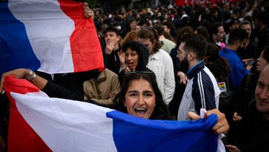 A partcipant holds a French national flag during a demonstration following the announcement of the projected results of the second round of Frances crunch legislative elections during a rally in Nantes, western France on July 7, 2024. A loose alliance of French left-wing parties thrown together for snap elections was on course to become the biggest parliamentary bloc and beat the far right, according to shock projected results. (Photo by Loic VENANCE / AFP)